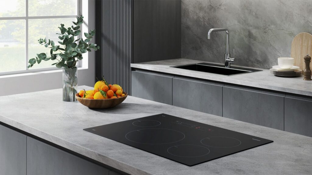 Flass black induction cooktop inset into gray countertop in upscale kitchen - photo