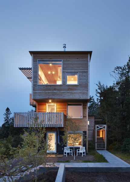 exterior view of modern home with wood siding and balconies; creative architecture with cantilevered design - photo