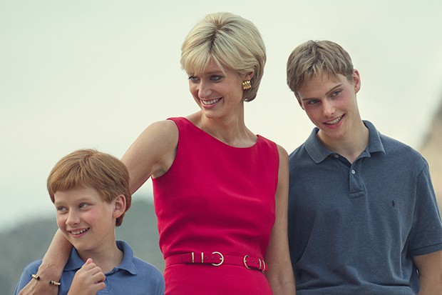 Fflyn Edwards as Prince Harry, Elizabeth Debicki as Princess Diana, and Rufus Kampa as Prince William in The Crown season 6 standing together, smiling