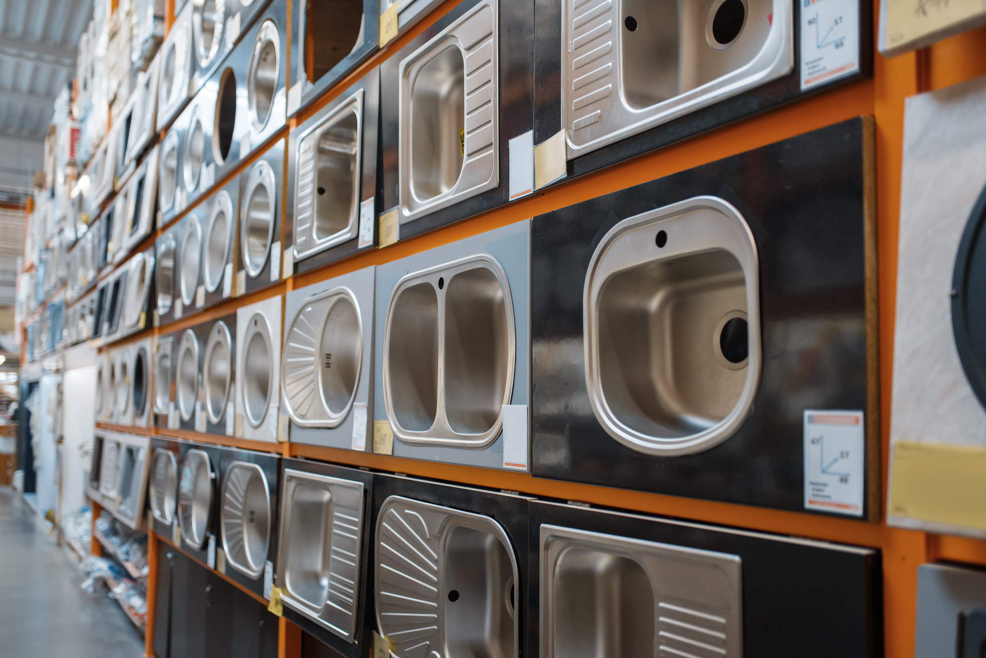 Hardware store assortment, shelf with stainless steel mortise sinks, nobody. Building materials and tools choice in diy shop, rows of products on racks